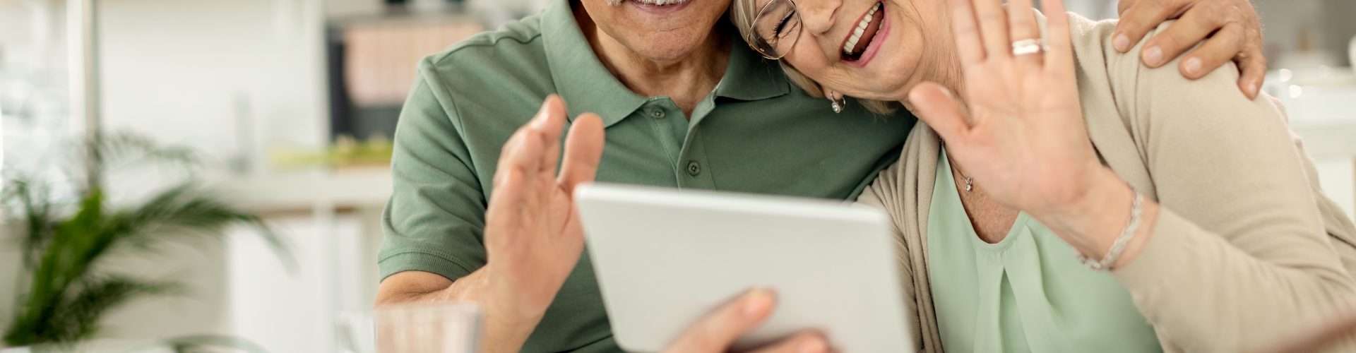 Happy,Senior,Couple,Using,Touchpad,And,Waving,While,Greeting,Someone